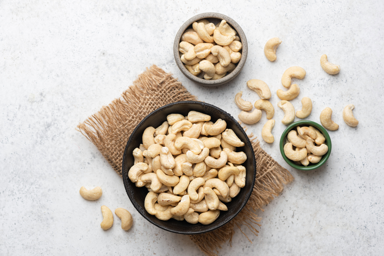 Organic whole cashew nuts in three different sized bowls